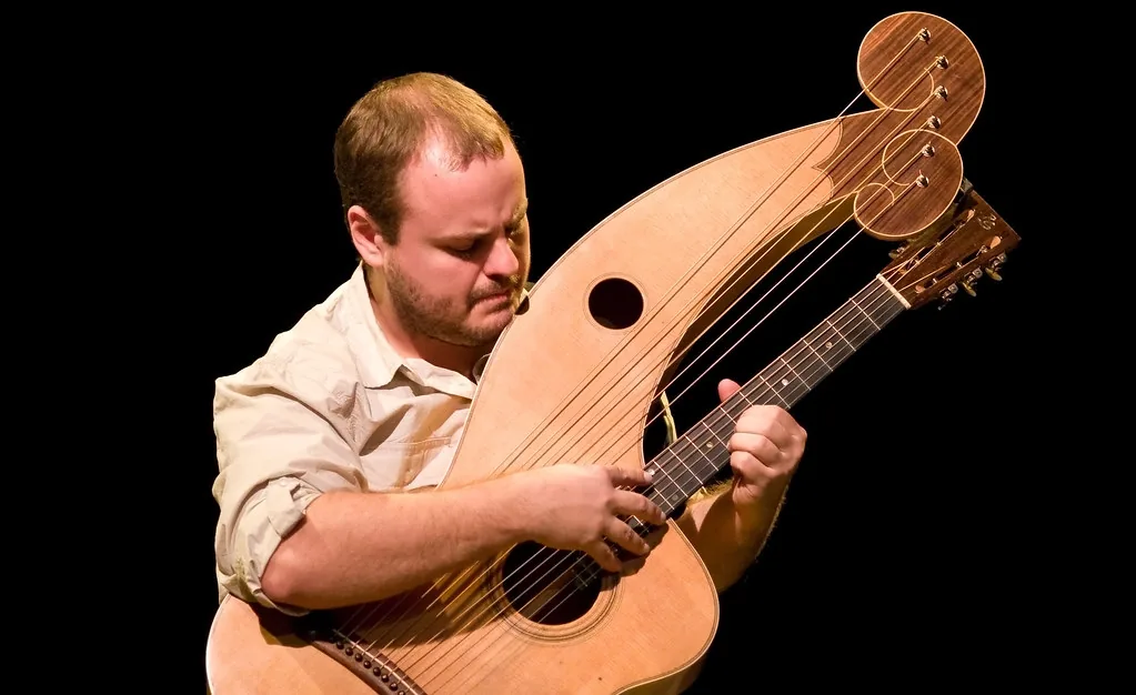 musician playing a harp guitar musician playing a harp guitar
