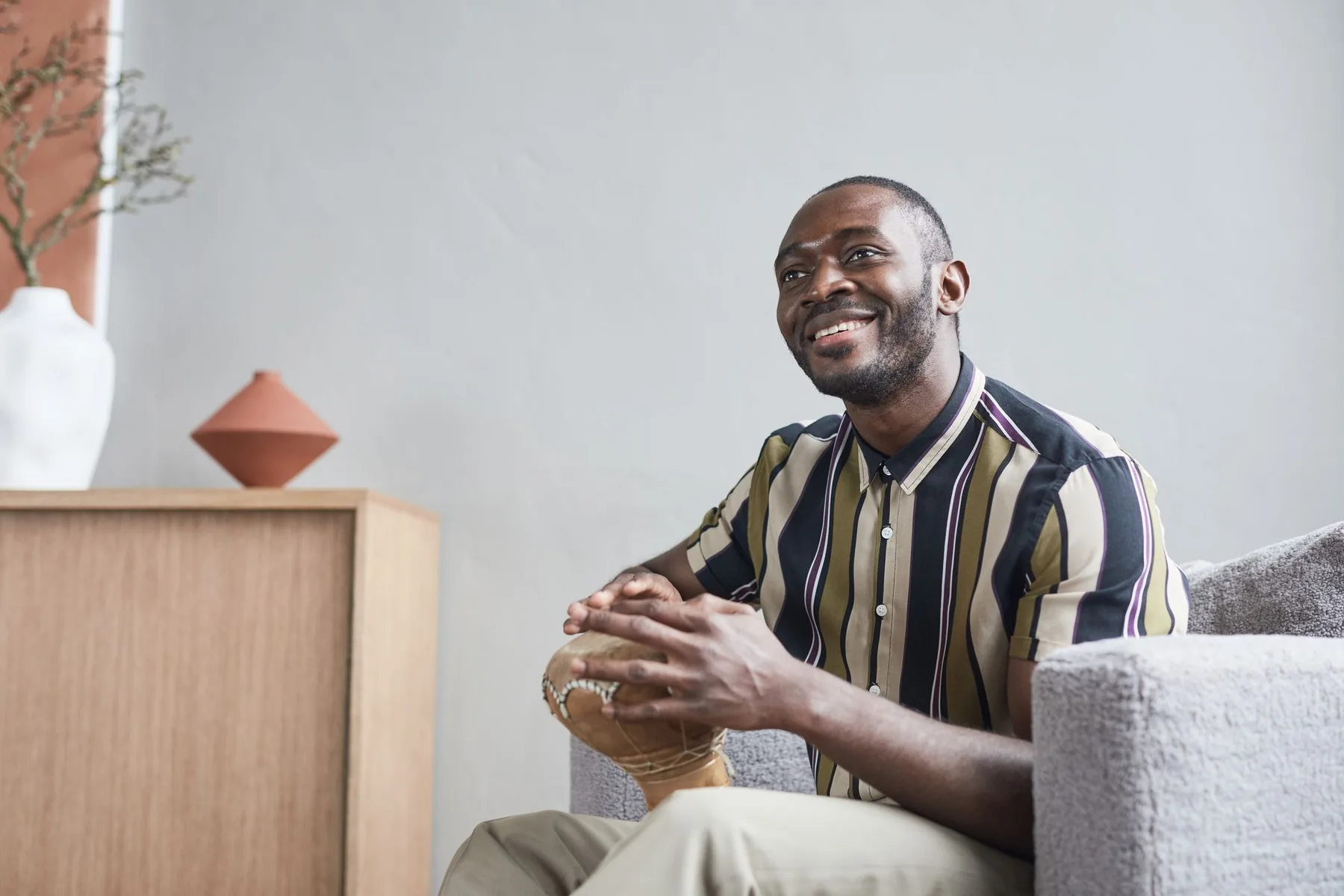 Musicien jouant du djembé assis Musicien jouant du djembé assis