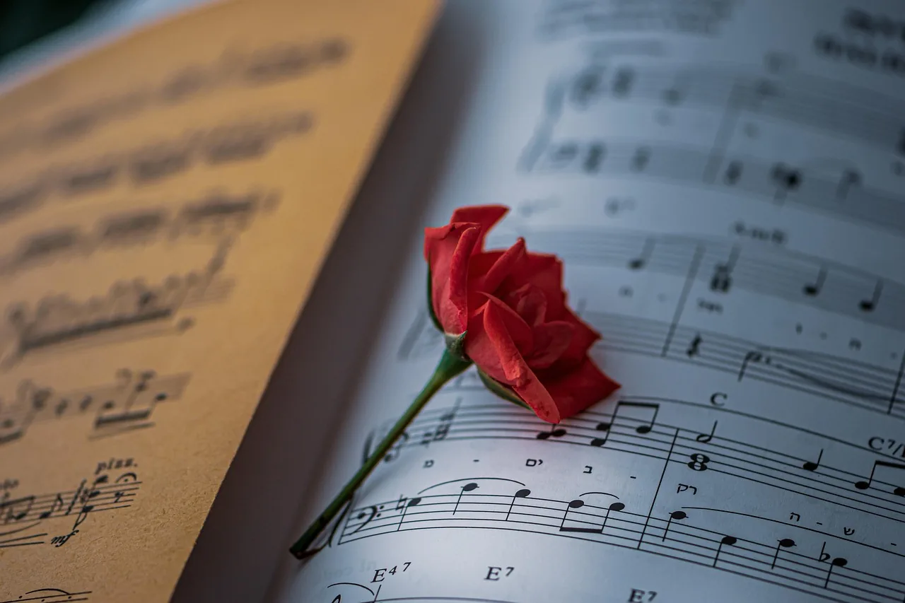 Sheet music with a red rose