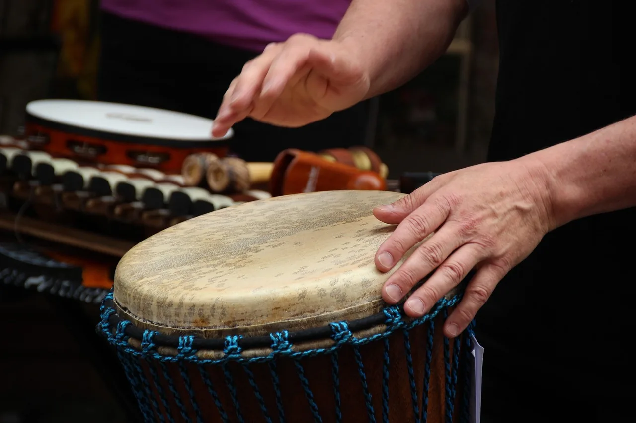 Hand testing the head of a djembe Hand testing the head of a djembe